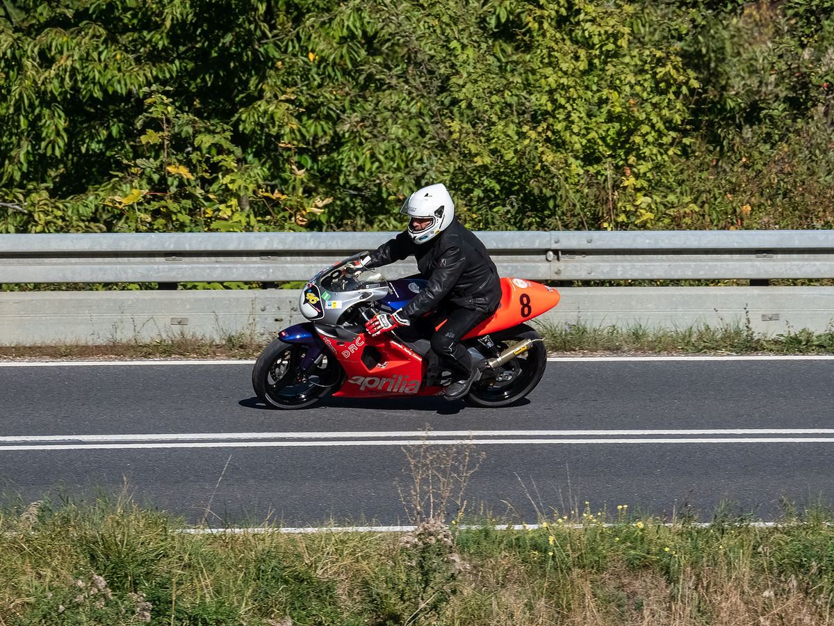 Rode Aprilia RS 125 in een bocht op een bergweg